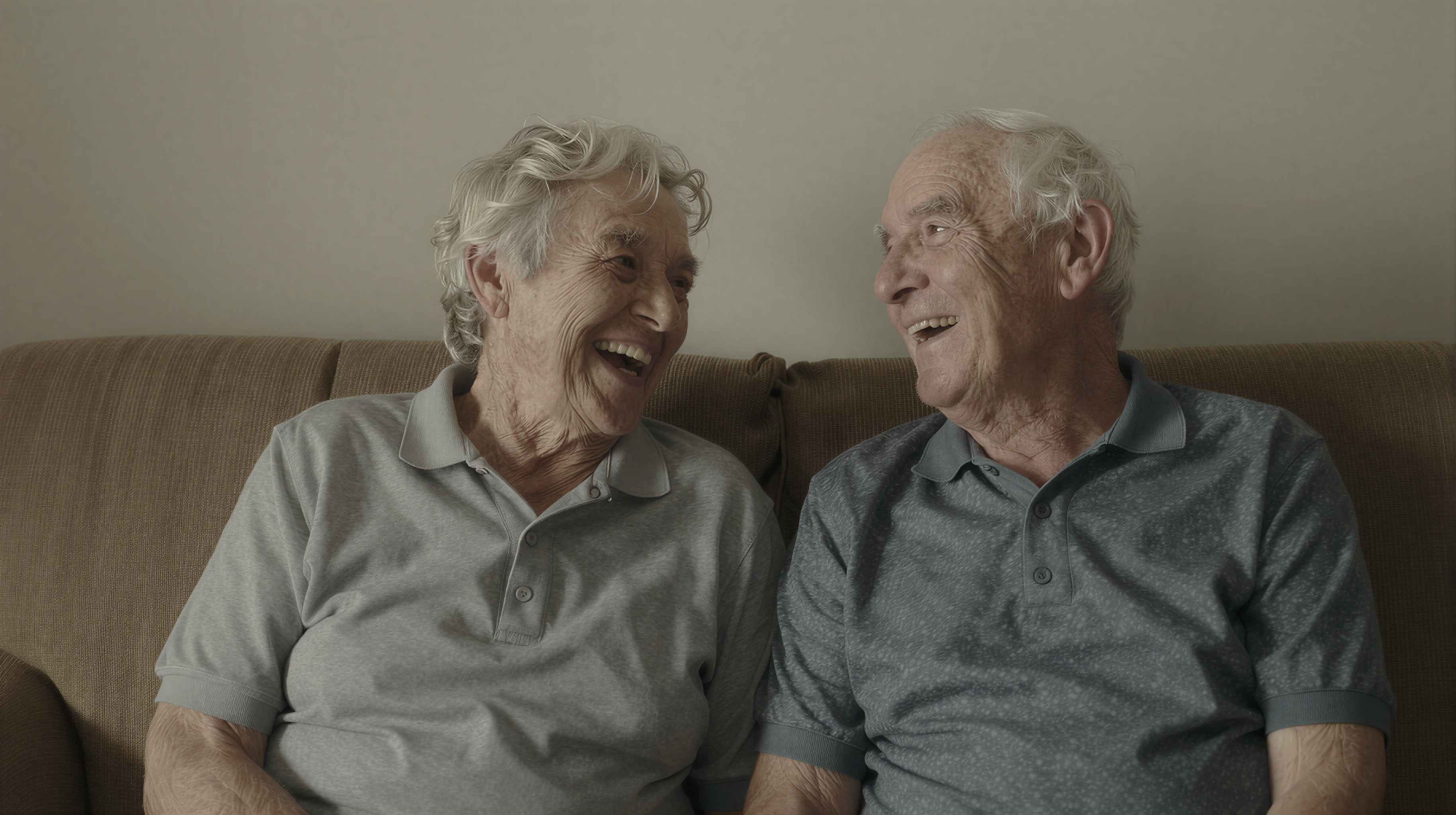 Elderly couple laughing together on couch
